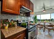 Thumbnail 10 of 39 - A kitchen with a stove top oven and a fan.