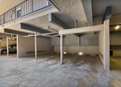 Thumbnail 3 of 39 - A large, empty parking garage with concrete pillars and a metal railing.