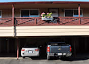 Thumbnail 3 of 16 - a parking lot with two cars in front of a building