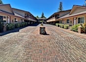 Thumbnail 1 of 16 - a courtyard with brick sidewalks and buildings with a fountain