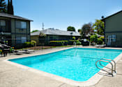 Thumbnail 25 of 27 - A swimming pool surrounded by a fence and chairs.