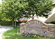 Thumbnail 9 of 11 - a stone sign that says in front of trees and flowers