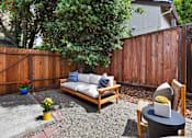 Thumbnail 21 of 27 - A backyard with a wooden fence and a bench.
