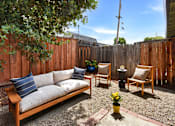 Thumbnail 20 of 27 - A backyard with a wooden bench and chairs.