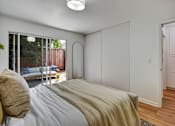 Thumbnail 19 of 27 - A bedroom with a bed and a window overlooking a backyard.