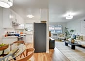 Thumbnail 12 of 27 - A modern kitchen with a glass table and a black refrigerator.