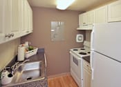 Thumbnail 18 of 18 - A kitchen with white appliances and wooden cabinets.