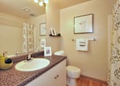 Thumbnail 13 of 18 - A bathroom with a sink, toilet, and shower curtain.