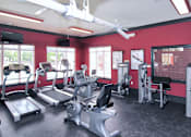 Thumbnail 11 of 18 - A gym with treadmills, exercise bikes, and other equipment.