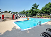 Thumbnail 7 of 18 - A pool with a diving board and a small building.