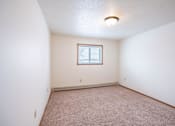 Thumbnail 14 of 18 - A room with a window and carpeted floor. Fargo, ND Cedars 4 Apartments