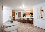 Thumbnail 3 of 18 - A white marble table with a vase of white flowers on it sits in a kitchen. Fargo, ND Cedars 4 Apartments