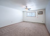 Thumbnail 5 of 18 - A room with a ceiling fan and a window. Fargo, ND Cedars 4 Apartments