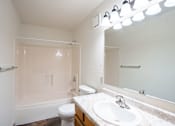 Thumbnail 43 of 44 - A white bathroom with a toilet, sink, and mirror.