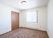 Thumbnail 36 of 44 - A room with a brown carpet and a window with blinds.