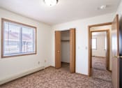 Thumbnail 39 of 44 - A room with a carpeted floor, a window, and a door.