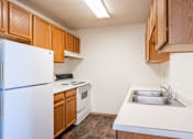 Thumbnail 34 of 44 - A kitchen with a white refrigerator and wooden cabinets.