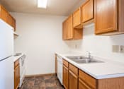 Thumbnail 33 of 44 - A kitchen with brown cabinets and a white fridge.