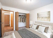 Thumbnail 4 of 13 - A bedroom with a large bed and a painting on the wall. Fargo, ND Candlelight Apartments