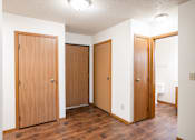 Thumbnail 7 of 13 - Three wooden doors in a white hallway. Fargo, ND Candlelight Apartment