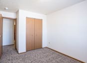 Thumbnail 26 of 44 - A room with a brown door and carpeted floor. Fargo, ND Country Edge Apartments