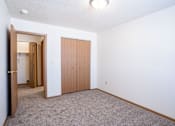Thumbnail 24 of 44 - A room with a carpeted floor and a closet. Fargo, ND Country Edge Apartments