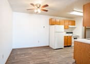 Thumbnail 22 of 44 - A kitchen with a white refrigerator and wooden cabinets. Fargo, ND Country Edge Apartments