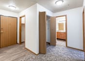 Thumbnail 29 of 44 - A room with a carpeted floor and white walls with a brown door and a wooden cabinet. Fargo, ND Country Edge Apartments