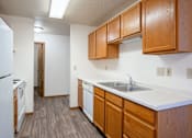 Thumbnail 21 of 44 - A kitchen with wooden cabinets and a white refrigerator. Fargo, ND Country Edge Apartments