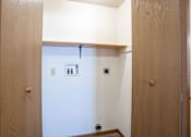 Thumbnail 28 of 44 - a closet with a shelf and laundry hookups. Fargo, ND Country Edge Apartments