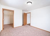Thumbnail 19 of 23 - A bedroom with a carpeted floor and a walk in closet. Fargo, ND Somerset Apartments