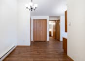 Thumbnail 16 of 23 - A hallway with a chandelier and a wooden floor. Fargo, ND Somerset Apartments