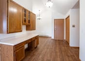 Thumbnail 15 of 23 - A desk with wooden cabinets and a white top. Fargo, ND Somerset Apartments