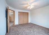 Thumbnail 18 of 23 - A room with a ceiling fan and carpeted floor. Fargo, ND Summit Point Apartments