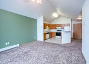 Thumbnail 14 of 23 - A room with a kitchen area in the background. Fargo, ND Summit Point Apartments