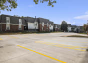 Thumbnail 21 of 21 - Omaha, NE Beacon Hill Apartments. A parking lot with a row of apartments in the background