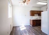 Thumbnail 16 of 21 - A kitchen with a white refrigerator and wooden floors. Bismarck, ND Belmont Apartments