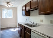Thumbnail 15 of 21 - A kitchen with wooden cabinets and a white dishwasher. Bismarck, ND Belmont Apartments