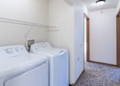 Thumbnail 20 of 21 - A small laundry room with a washer and dryer. Dilworth, MN Fieldstone Apartments