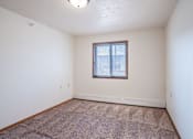 Thumbnail 18 of 21 - A room with a window and carpeted floor. Dilworth, MN Fieldstone Apartments