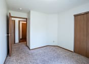 Thumbnail 14 of 30 - A room with a carpeted floor and two wooden doors.
