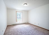 Thumbnail 11 of 30 - A room with a window and a carpeted floor.
