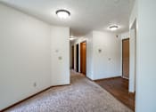 Thumbnail 10 of 30 - A long hallway with carpeted floors and white walls.