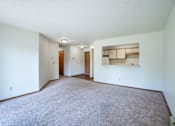 Thumbnail 8 of 30 - A large, empty room with carpeted floor and white walls.