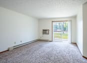 Thumbnail 7 of 30 - A room with a carpeted floor and a sliding glass door leading to a patio.