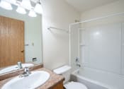 Thumbnail 19 of 20 - A white bathroom with a toilet, sink, and bathtub. West Fargo, ND Saddlebrook Apartments