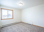 Thumbnail 14 of 20 - A room with a window and carpeted floor. West Fargo, ND Saddlebrook Apartments