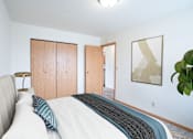 Thumbnail 3 of 20 - A bedroom with a bed, a lamp, and a painting on the wall. West Fargo, ND Saddlebrook Apartments