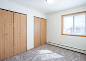 Thumbnail 15 of 20 - A room with a window and a carpeted floor. West Fargo, ND Saddlebrook Apartments