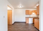 Thumbnail 13 of 20 - A kitchen with wooden floors and cabinets. West Fargo, ND Saddlebrook Apartments